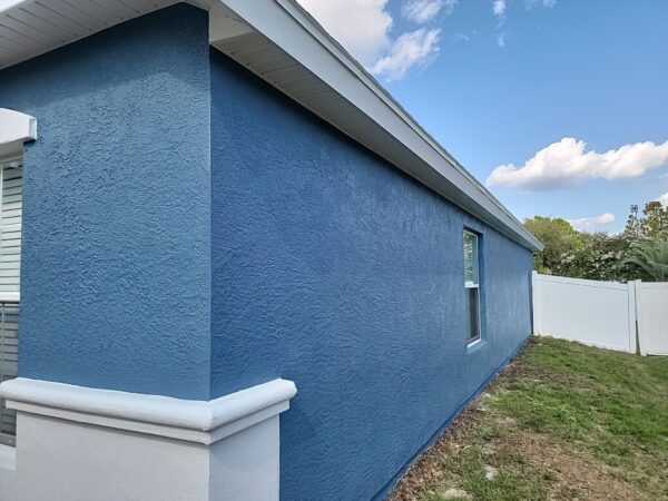 Exterior stucco painting project with refreshed wall finish and clean trim detail
